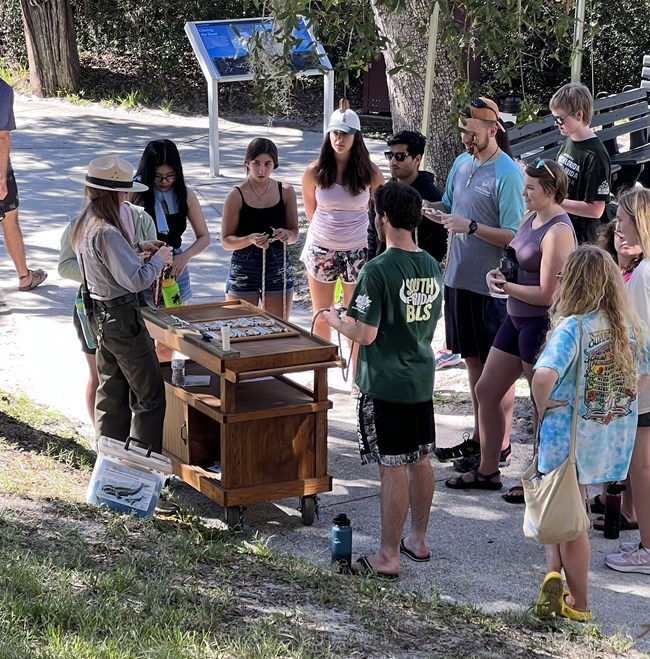 Park Ranger with a table showing how to tie knots to a group of visitors