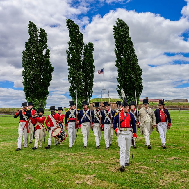 Soldiers and officer in War of 1812 militia uniforms with fort in background