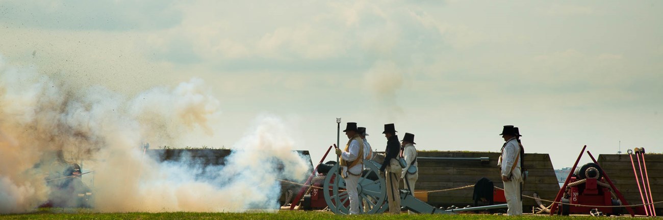 Living historians dressed as sea fencibles firing a cannon.