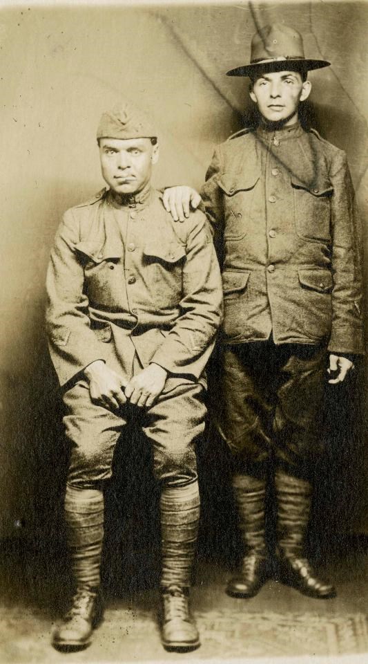 A black and white photograph of two World War I soldiers, one sitting and one standing. Each has a distorted face from needing facial reconstruction surgeries.