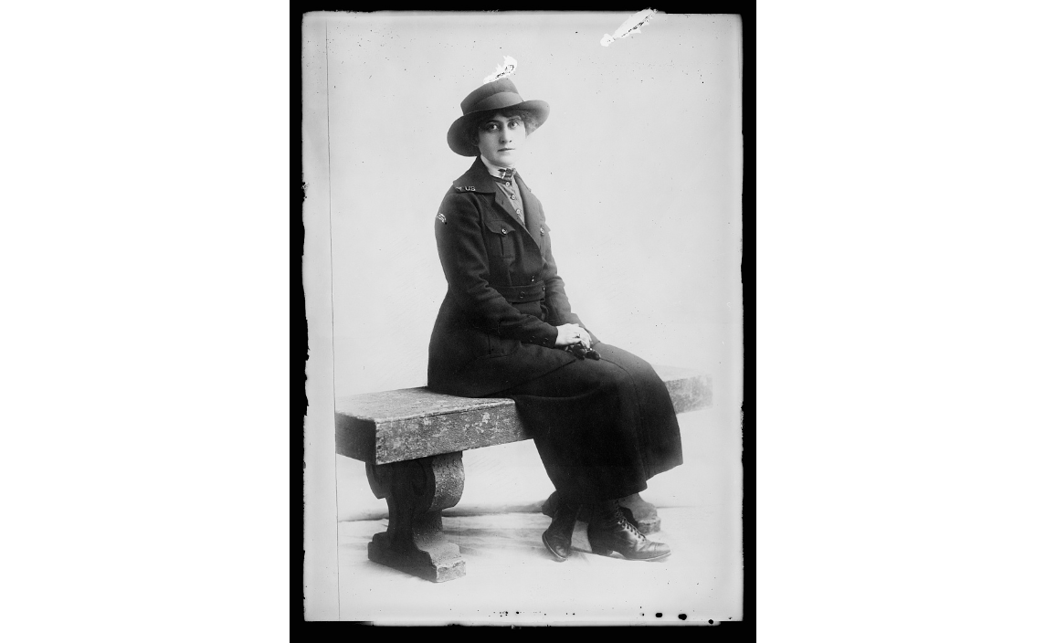 A black and white photograph of Mary Hickey sitting on a bench.