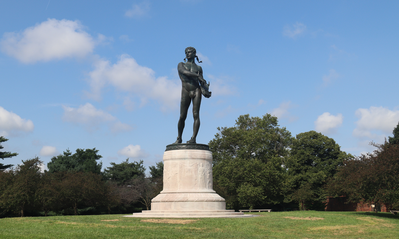 A color photograph of a monument with trees in background.