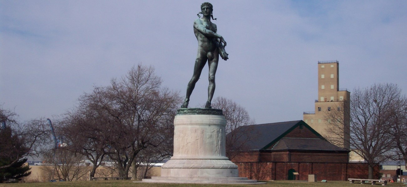 A color photograph of a monument with trees in background.