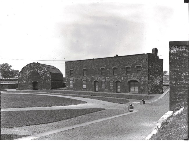 A black and white image of some of the buildings of Fort McHenry with the powder magazine on the left.