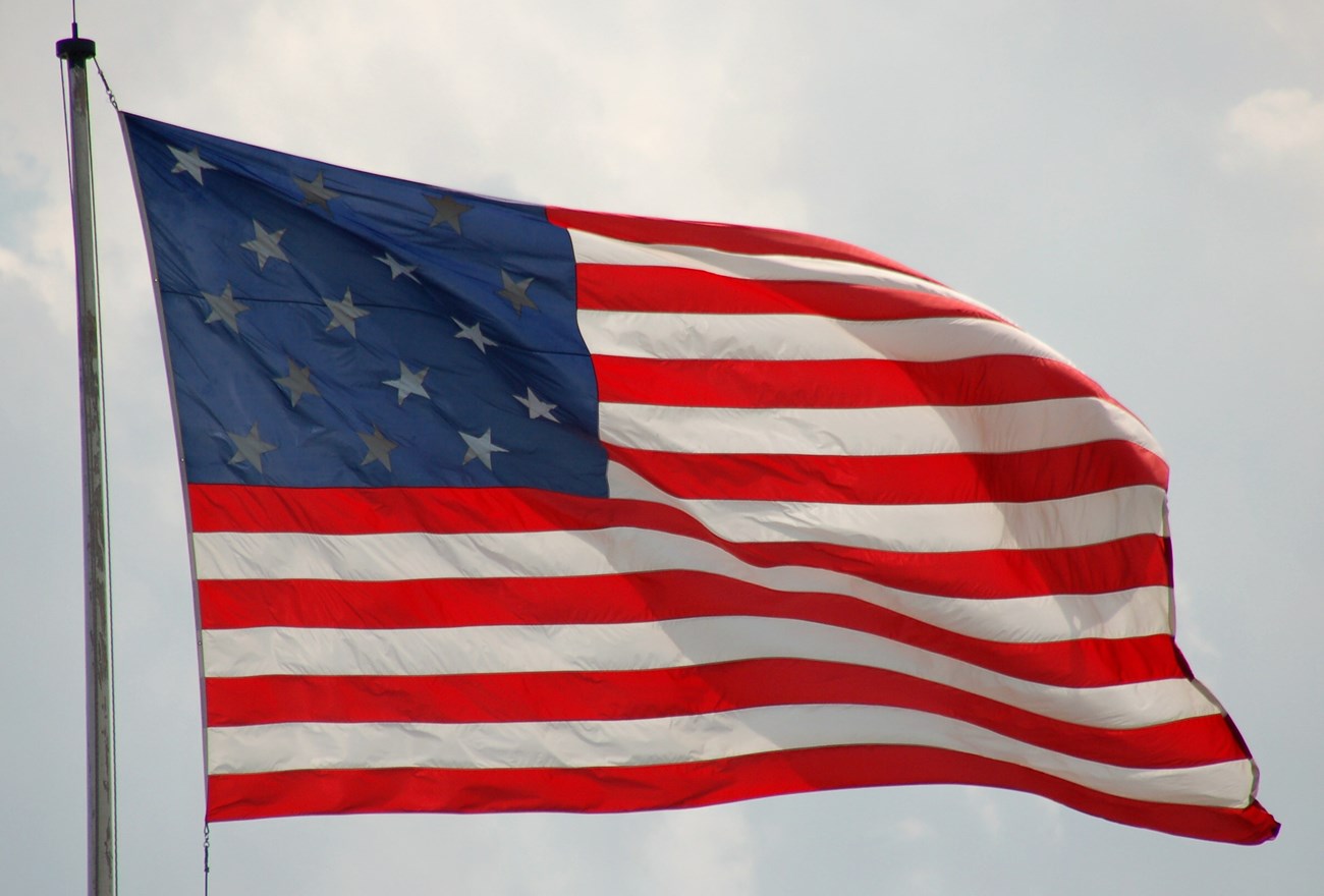 A 15 star and stripe American flag flutters in the wind.