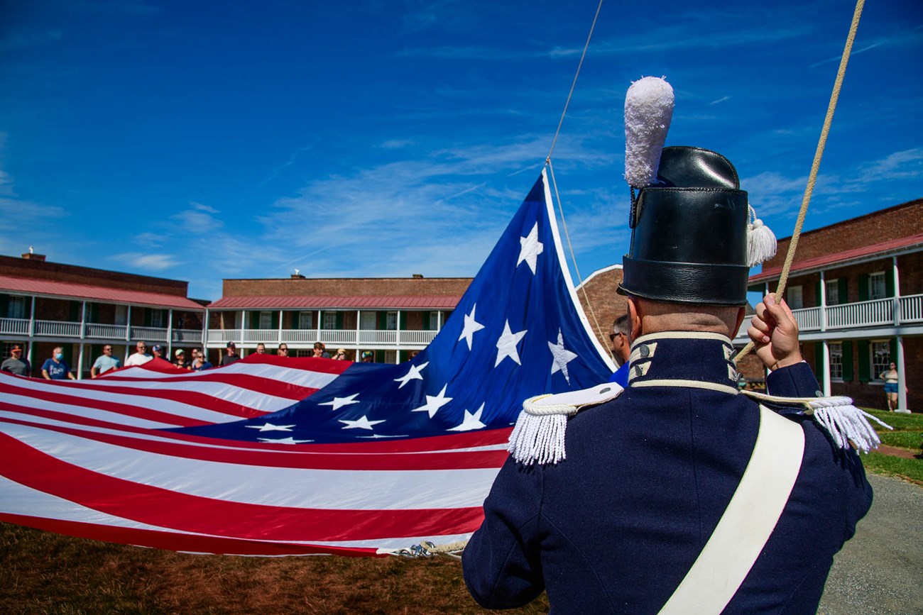 War of 1812 infantry soldier with Star-Spangled Banner in background
