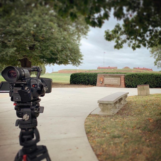 camera on tripod facing park sign