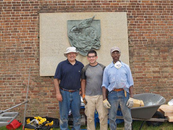 These men are preparing the new flagpole for installation.