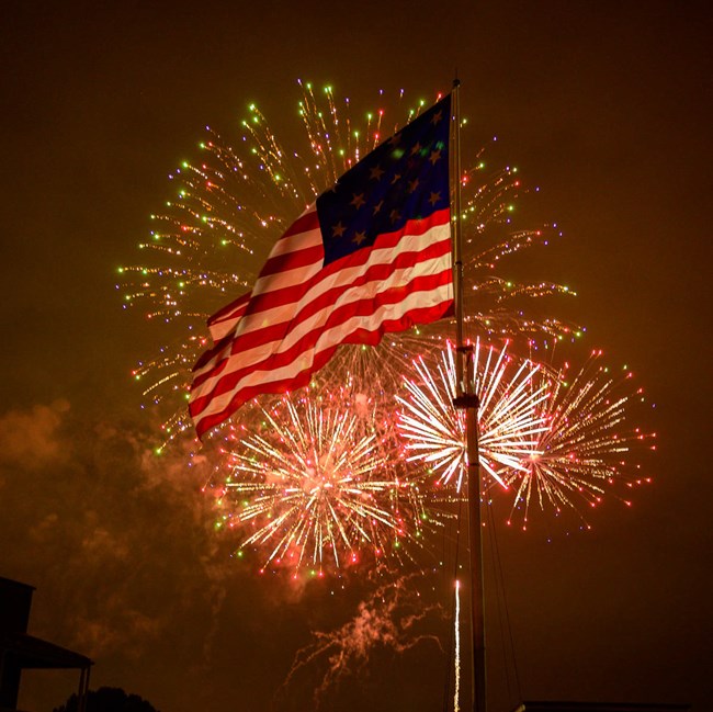 Fireworks behind the Star-Spangled Banner flag