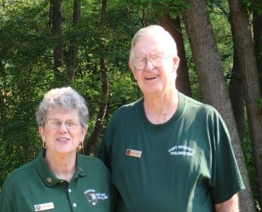 Two people wearing green shirts with the volunteer logo