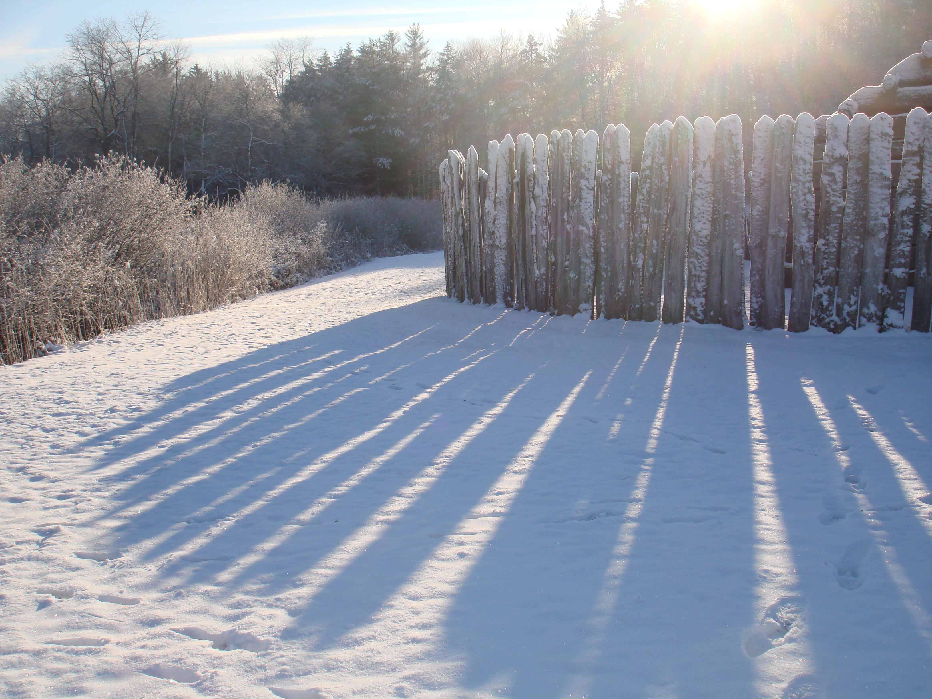 Fort Necessity in snow with low winter sun and long shadows