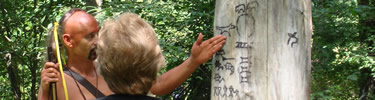 Indian explaining pictographs on tree