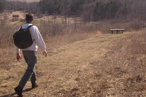 Hiker on trail overlooking Fort Necessity