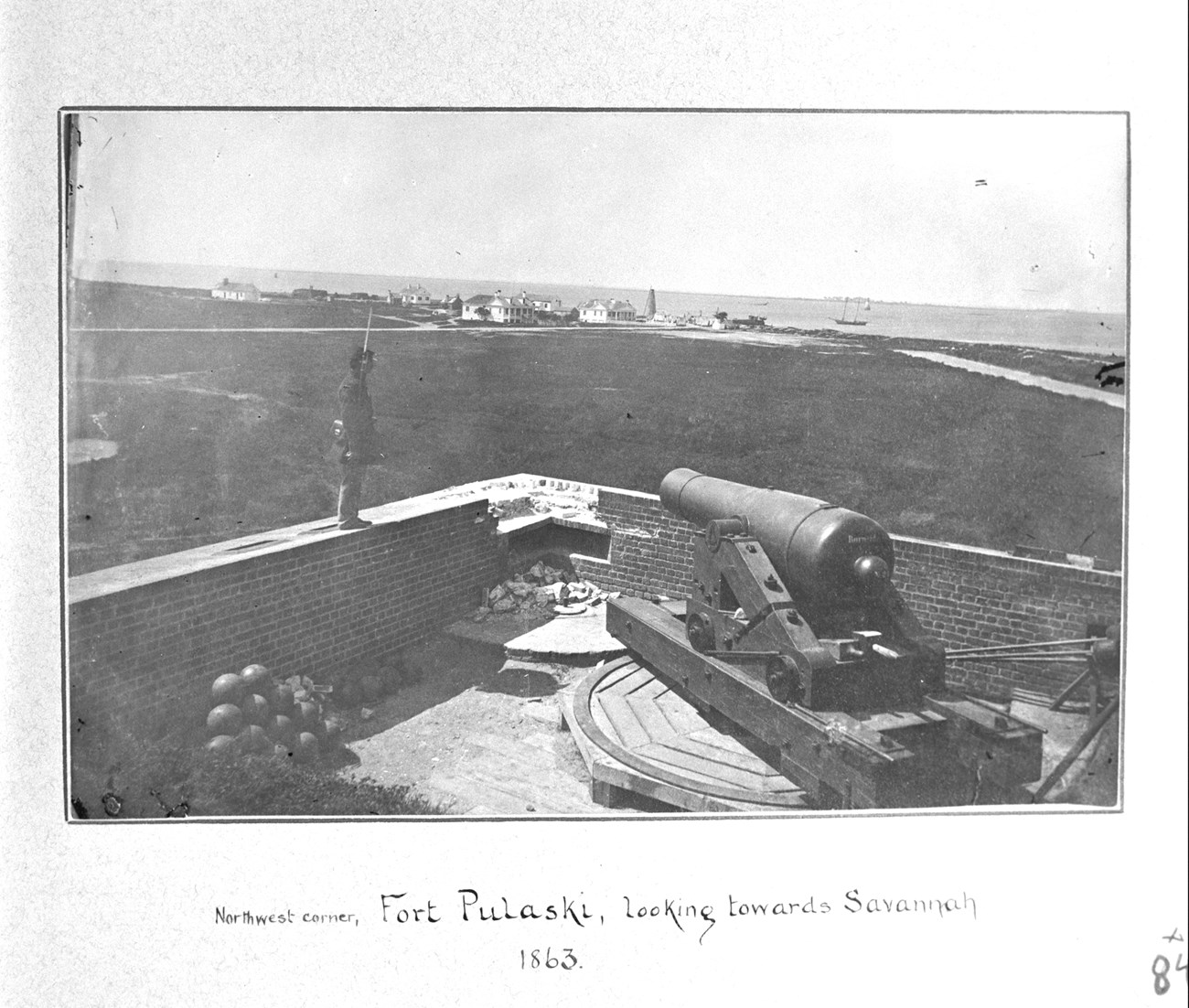 A Union soldier stands on the wall of Fort Pulaski looking towards the island's north shore.