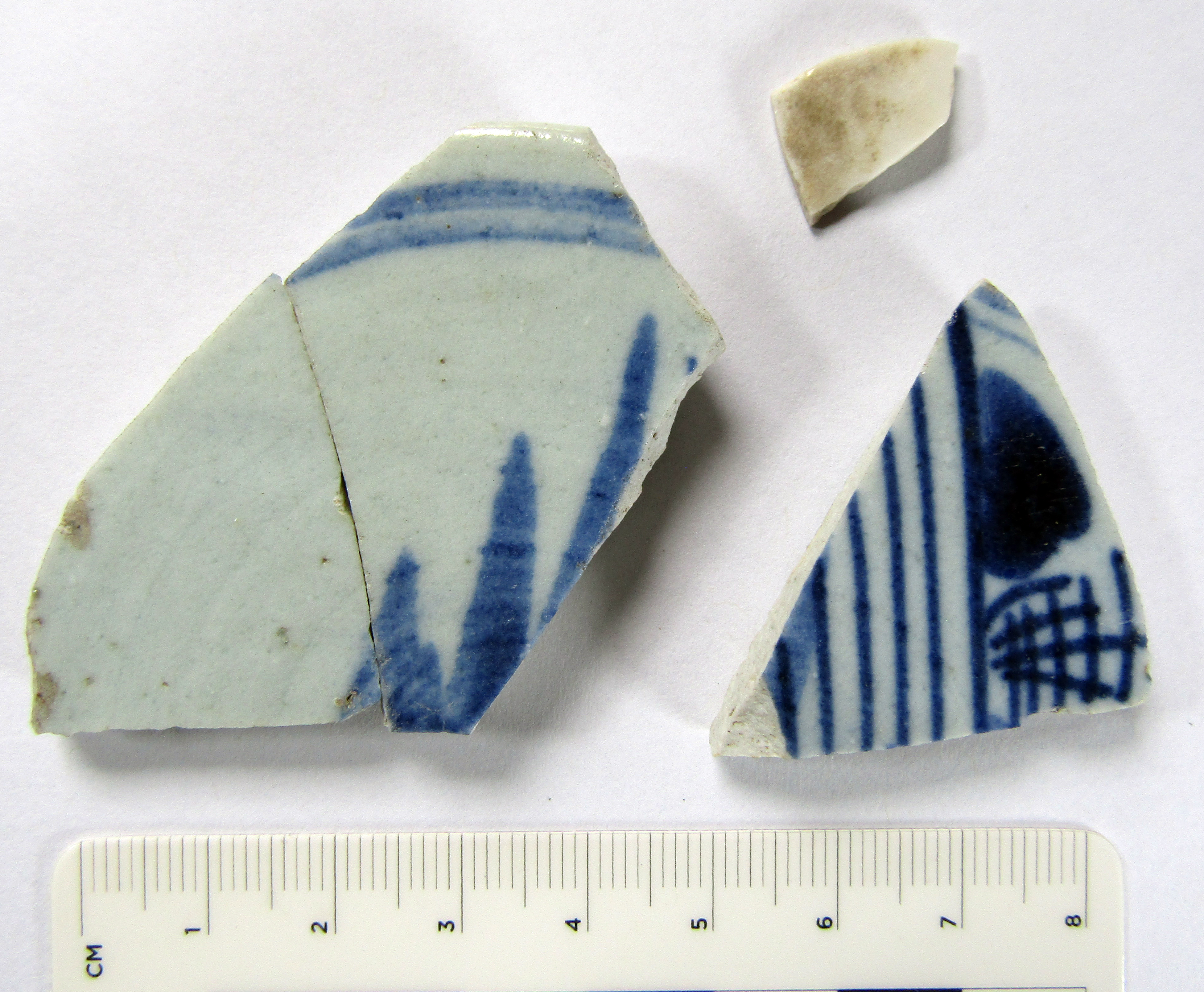 Three fragments of blue and white porcelain and one smaller fragment of white porcelain.