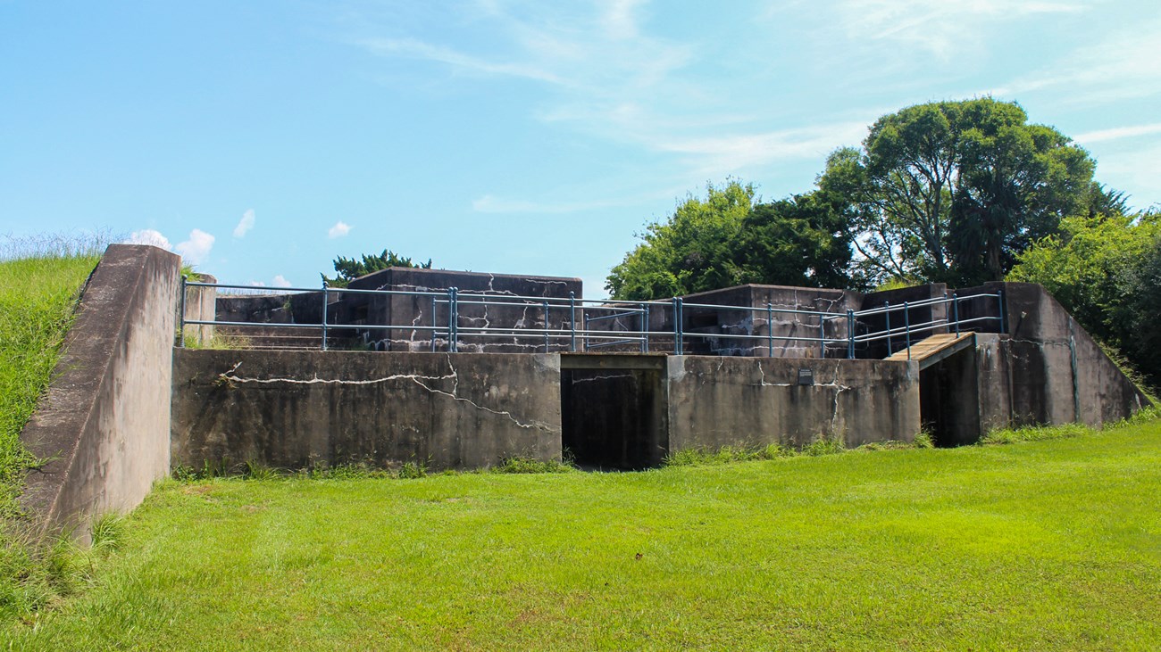 A one story concrete structure with two small staircases and metal railings.