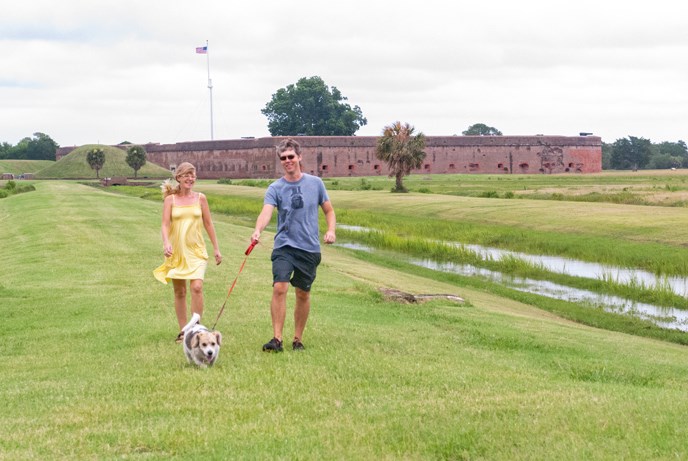 Visitors walk their dog outside the fort.