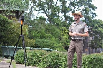 Ranger stands outside facing phone on a tripod