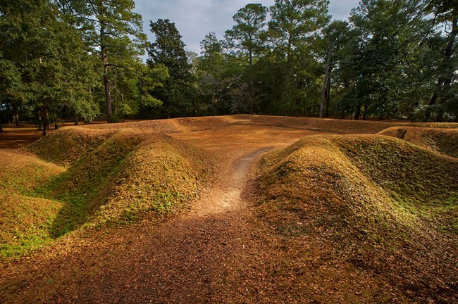 Reconstructed earthwork fort, covered in grass