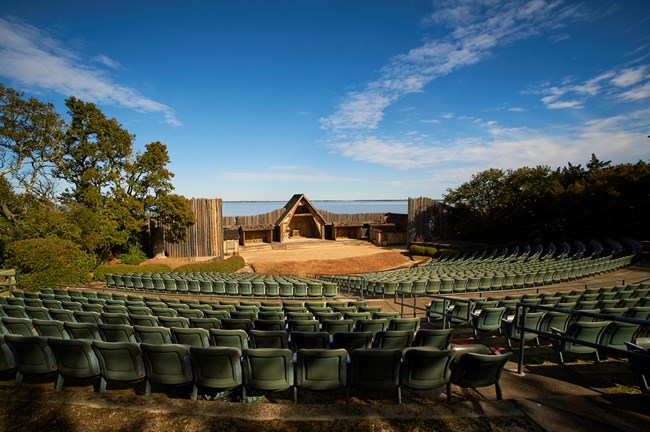 Outdoor amphitheater with rows of seats facing a stage.