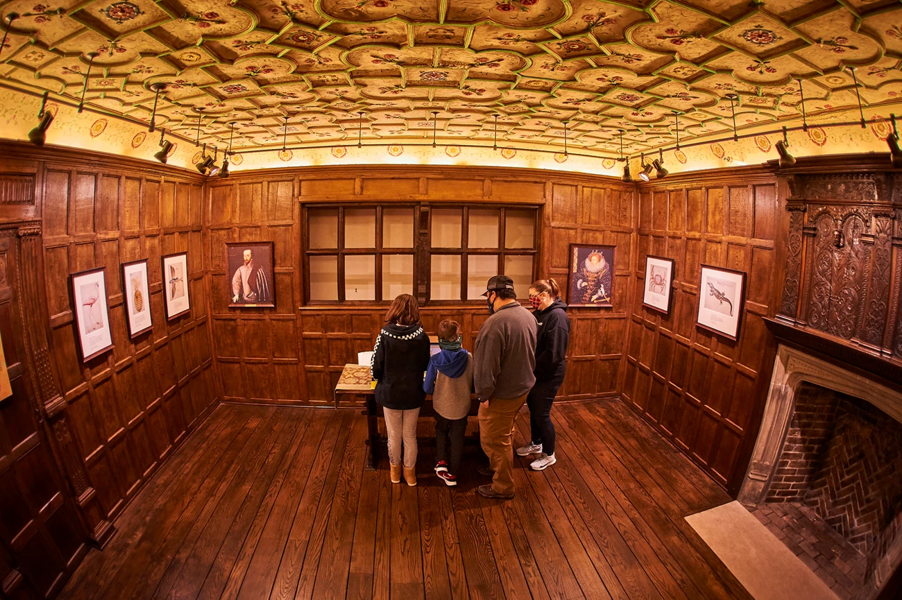 Elizabethan Room at Fort Raleigh Oak paneled room with plaster ceiling. Family reads exhibit.