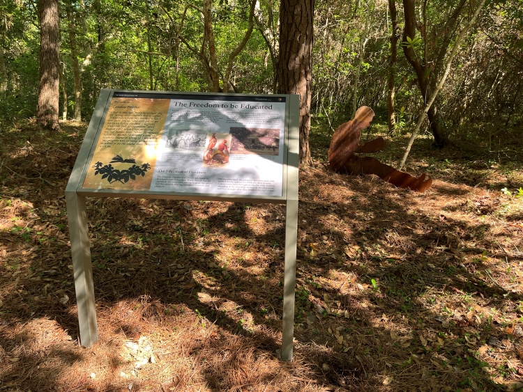 Freedom Trail educational panel and silhouette. Photo of an educational panel and silhouette along wooded trail.