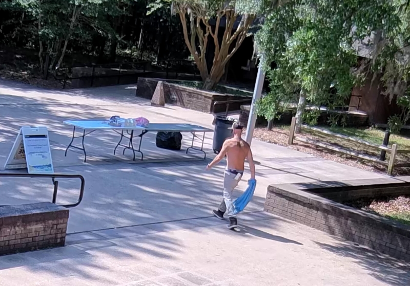 A white male walks toward a table.