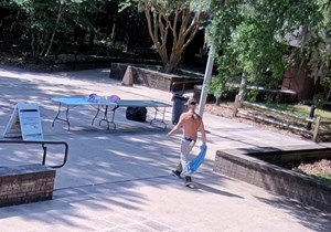 A white male walks toward a table.