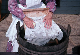 Laundress plunging hands into water