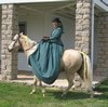 Woman riding sidesaddle on horseback