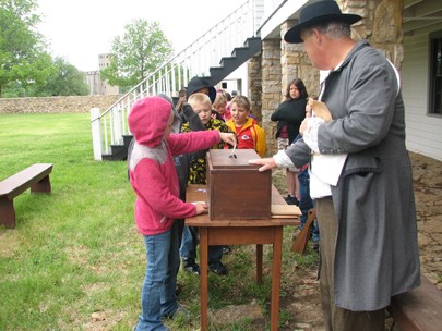 Students voting in a mock election held as one of three atations during an education program at Fort Scott.