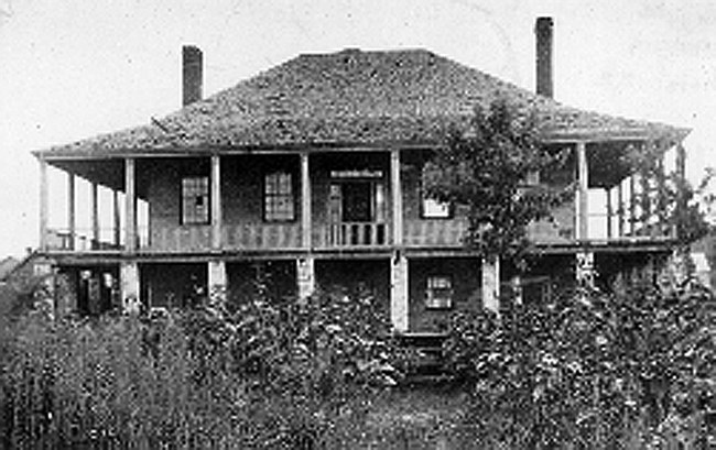 two story building with pillars and a slanted roofline