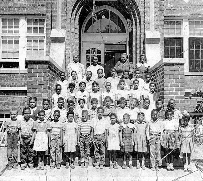 Hawkins class Black and white photo shows an orderly school class standing on stairs and looking toward the camera.