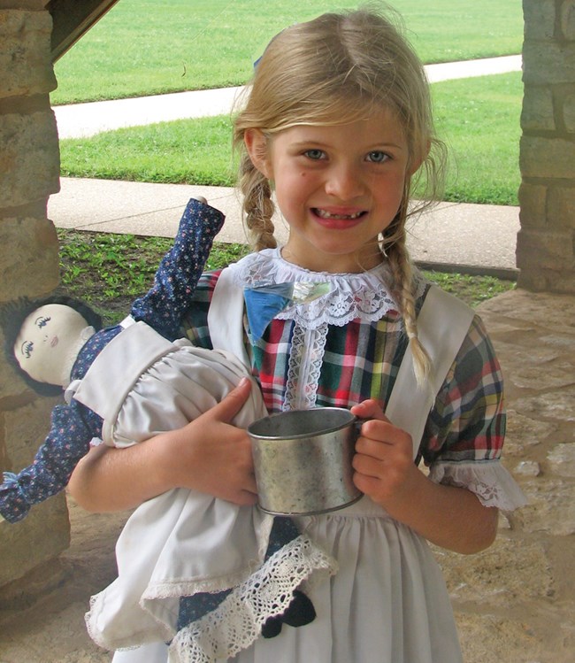 blonde haired girl with blue calico dress