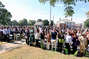 199 New Citizens standing and taking their oath on the grassy parade ground.