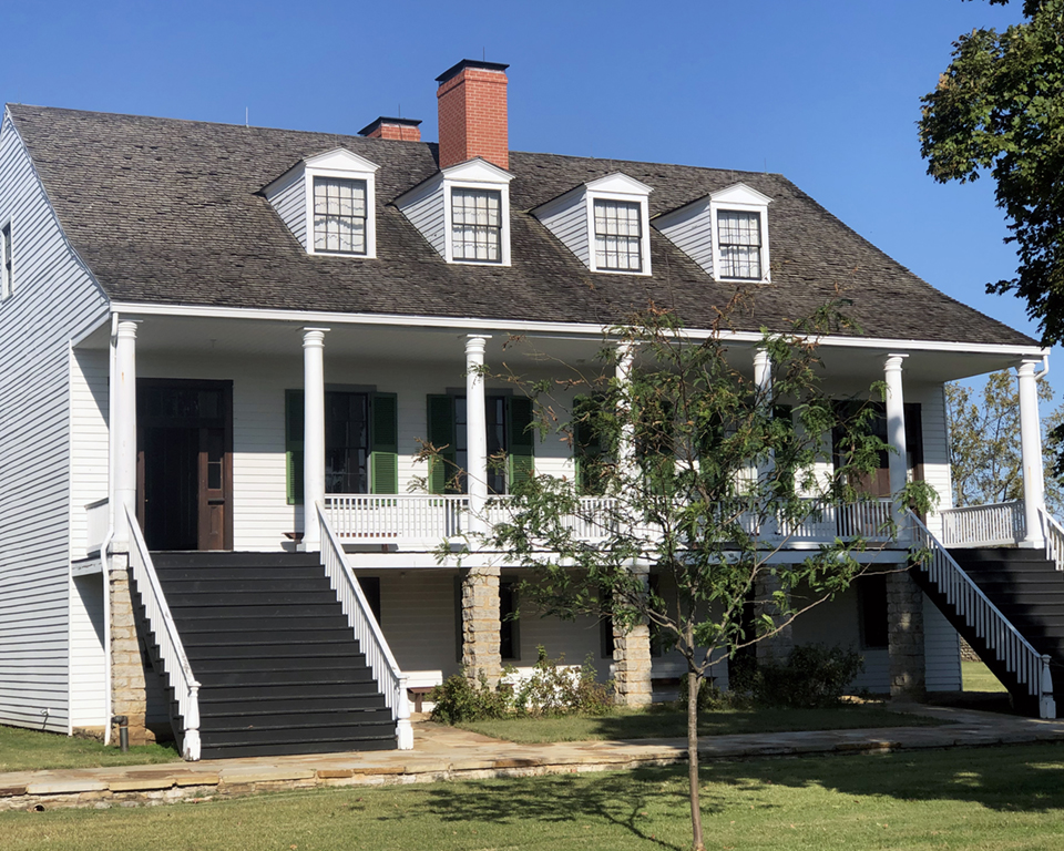 One of the Officer's Duplexes needing roofing repair. Picture of one of the Officer's Duplexes needing roofing repair, with a Locus tree in the foreground.
