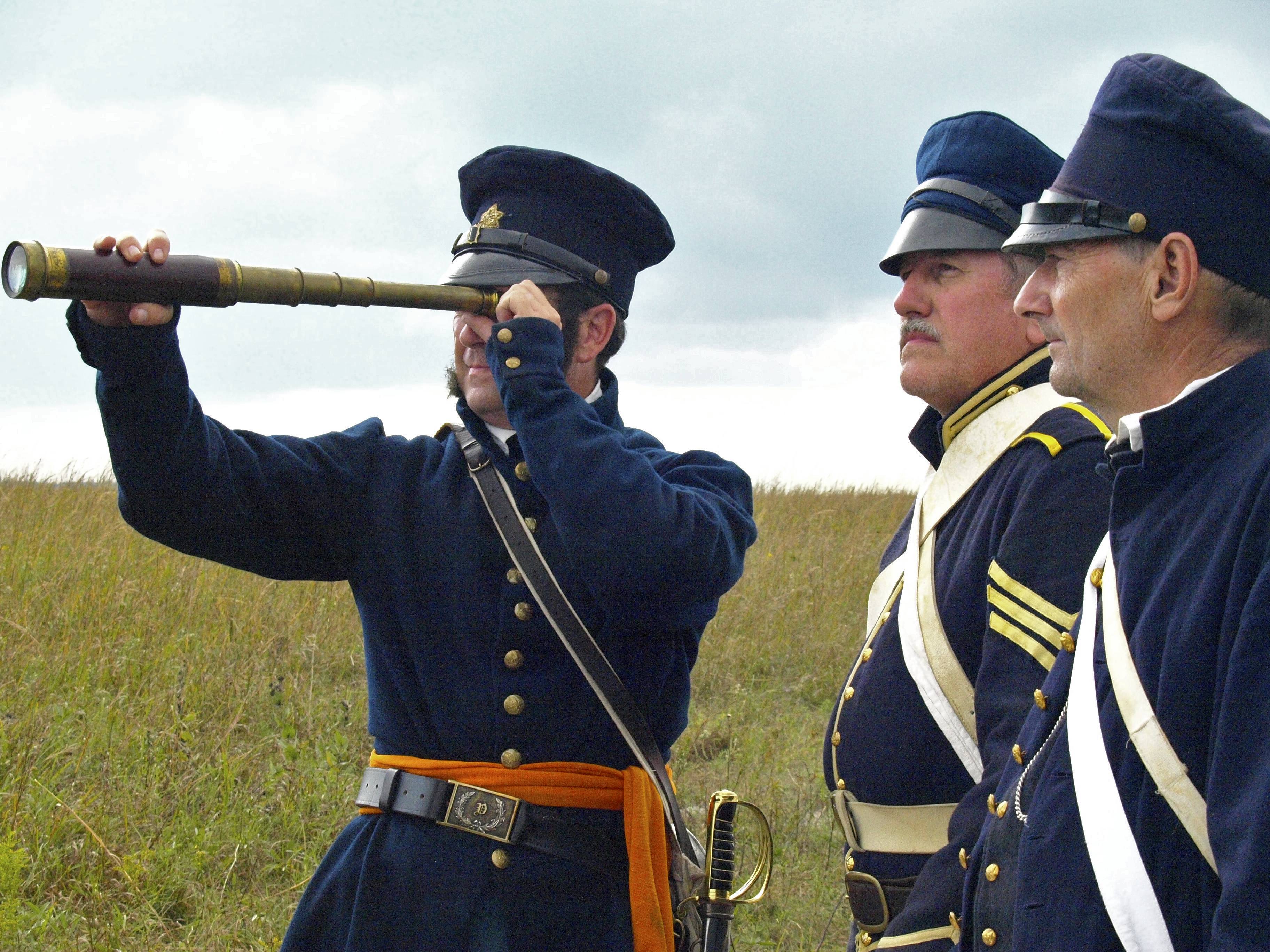 Three reenactors, one with telescope