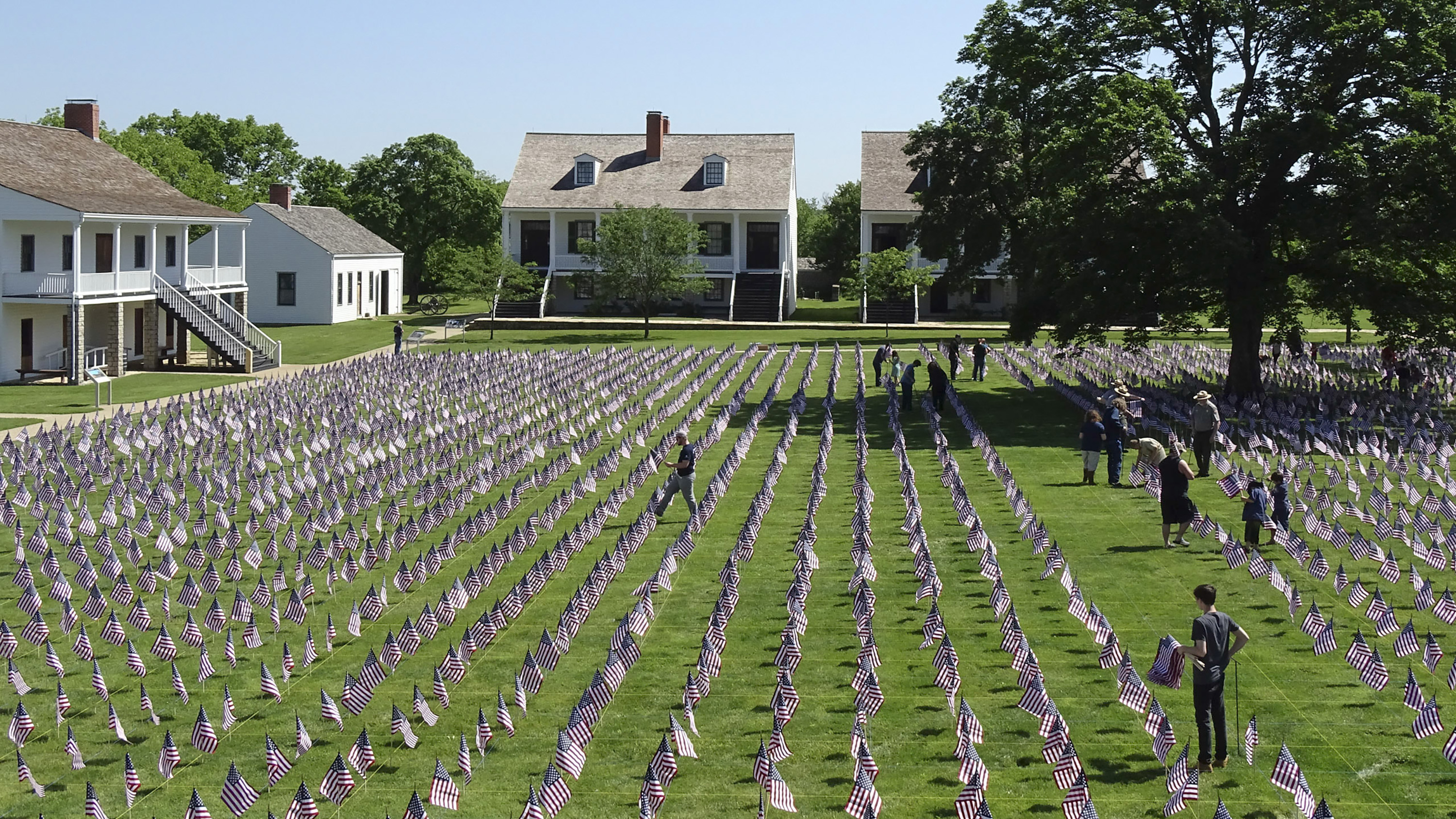 The 2022 Symbols of Sacrifice Field of Honor Staff and community members creating the Field of Honor with more than 7,000 flags on the fort's parade ground.