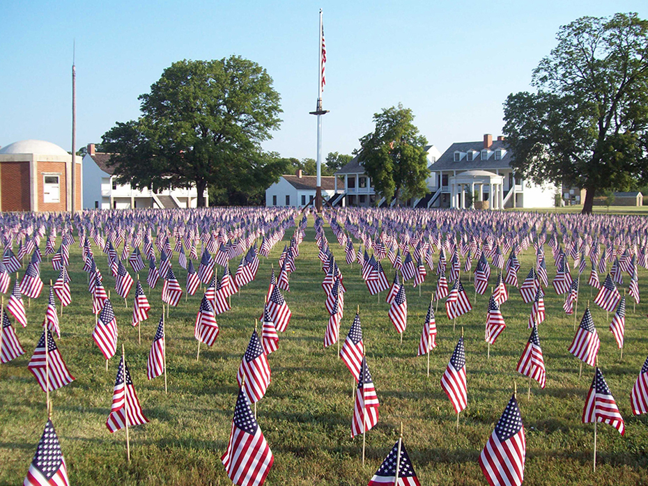 A view of a portion of the 7,000 flags on the parade ground with the post flag in the background.