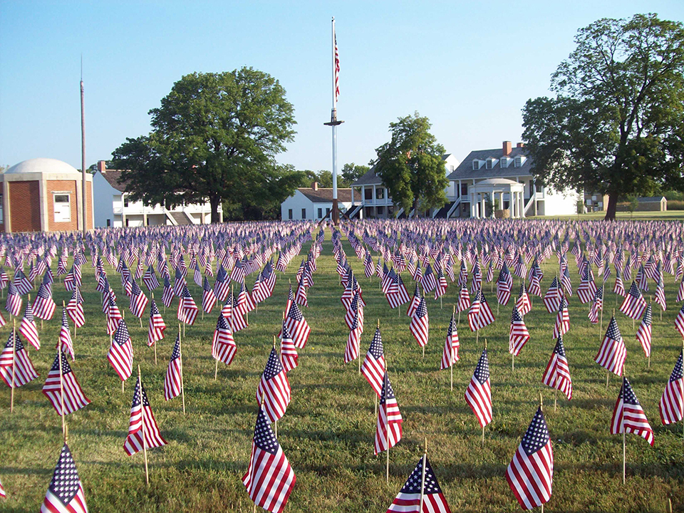 A view of a portion of the 7,000 flags on the parade ground with the post flag in the background.