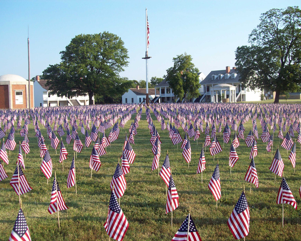 Fort Scott's Field of Honor A view of over 7,000 flags on Fort Scott's parade ground with post buildings and flag in the background.
