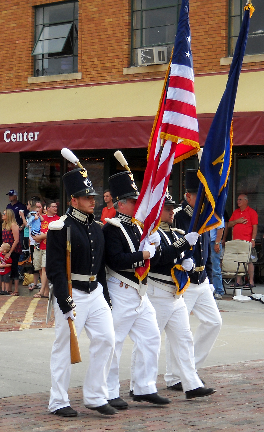 1840s infantry solders march as color guard Four reenactors dressed as 1840s infantry solders march as color guard in parade.