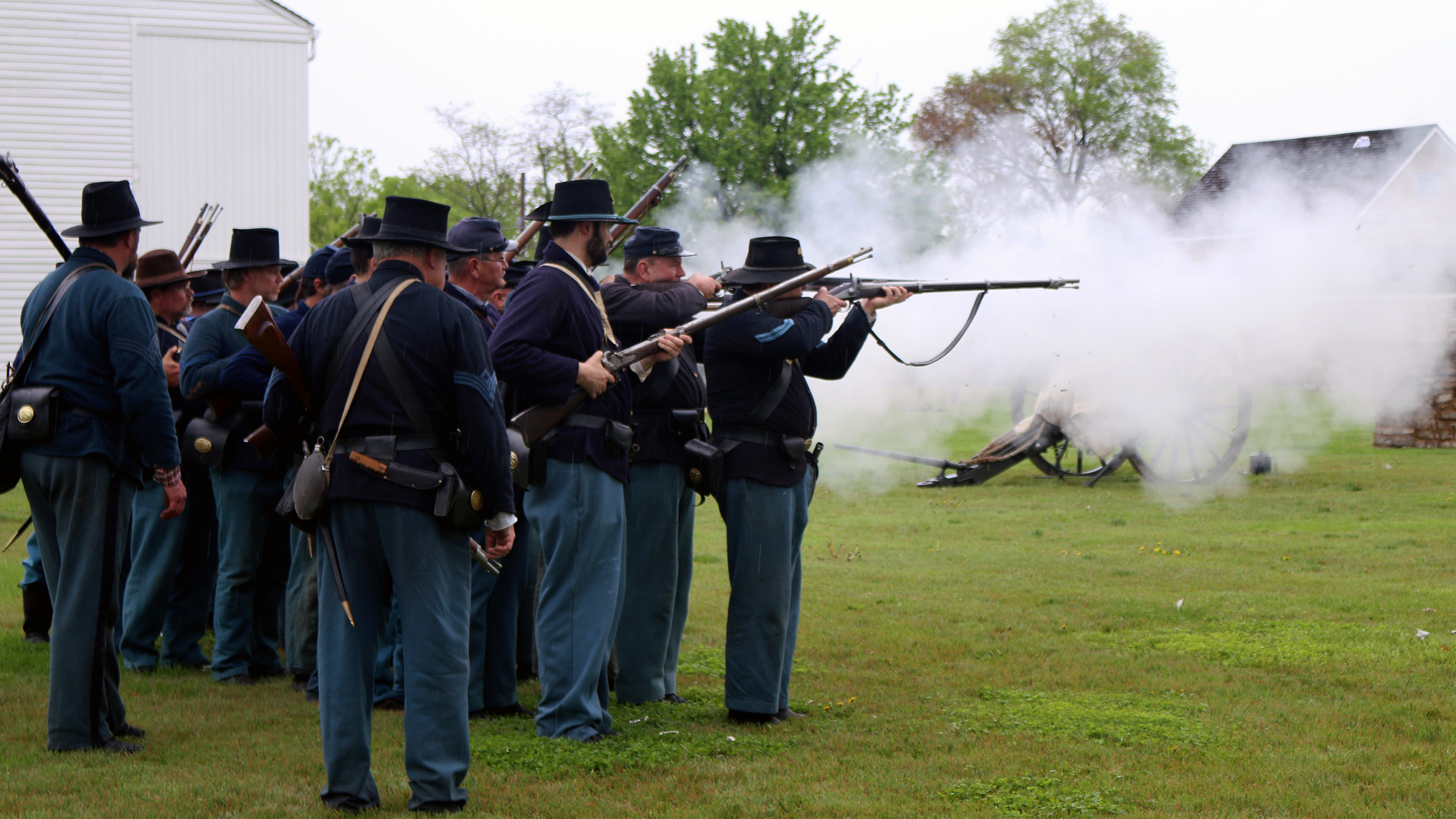 Group of Union Solderer reenactors firing black powder rifles.