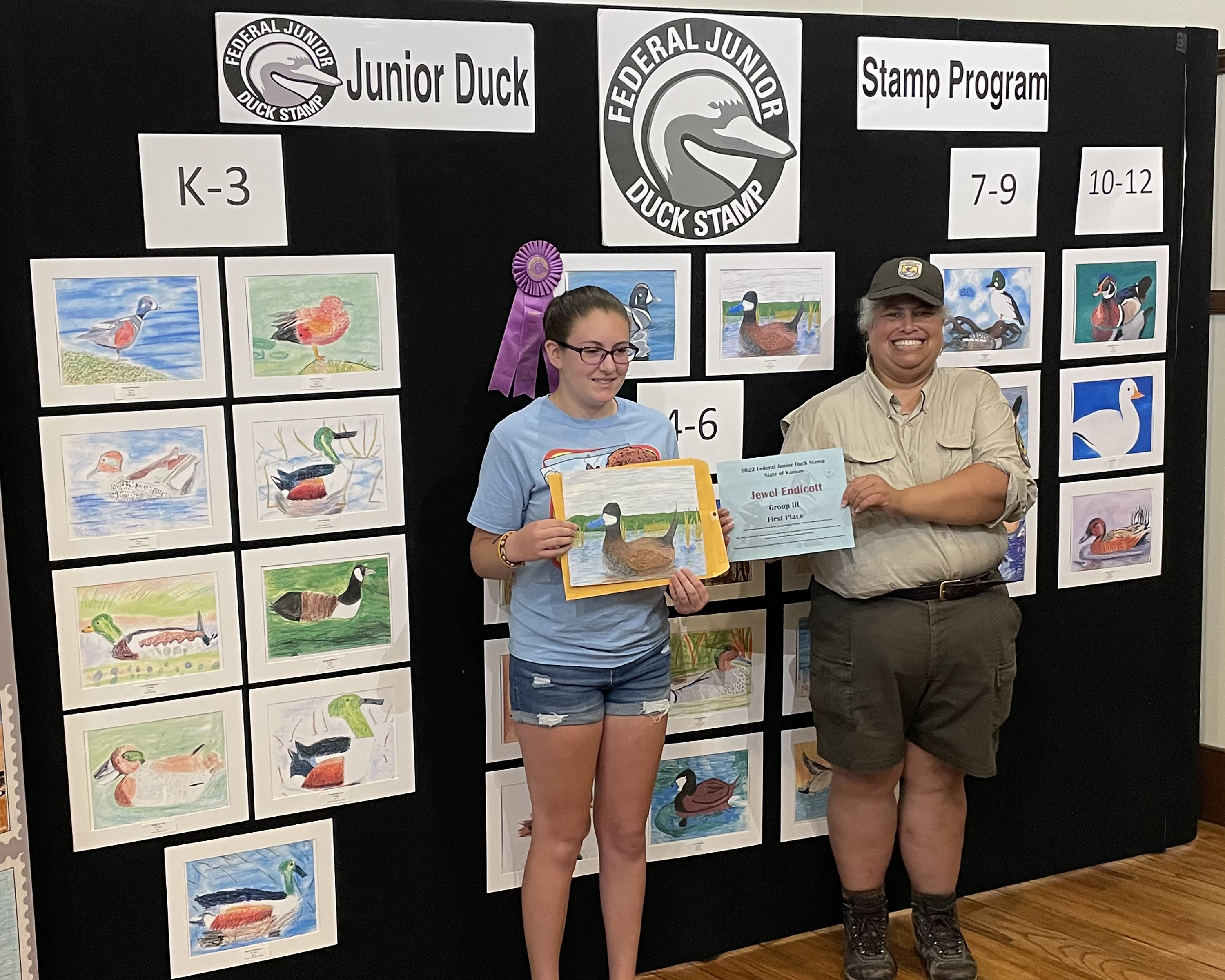 2022 Art contest winners. Jewel Endicott and Nova Clark are standing in front of the display of 2022 Art contest winners.