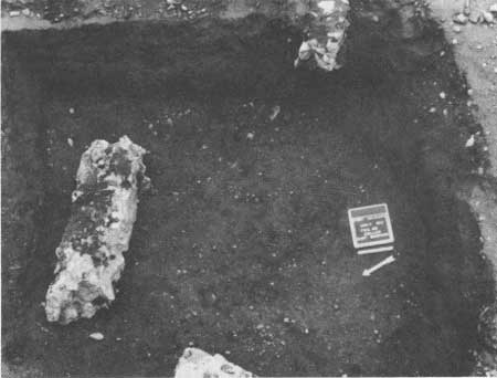 a carefully dug hole with dirty labeled itemes inside. black and white