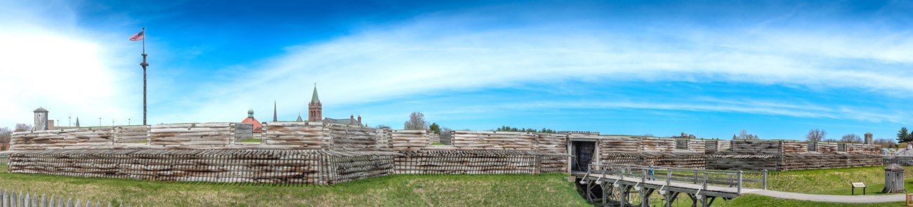 Stretched horizontally in front of you, an old wooden bridge leading into the walls of the fort.
