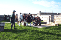 A cannon crew of six men stands on the bastion of the fort, preparing to roll the iron gun back to the embrasure and fire it. A cannon crew of six men stands on the bastion of the fort, preparing to roll the iron gun back to the embrasure and fire it.