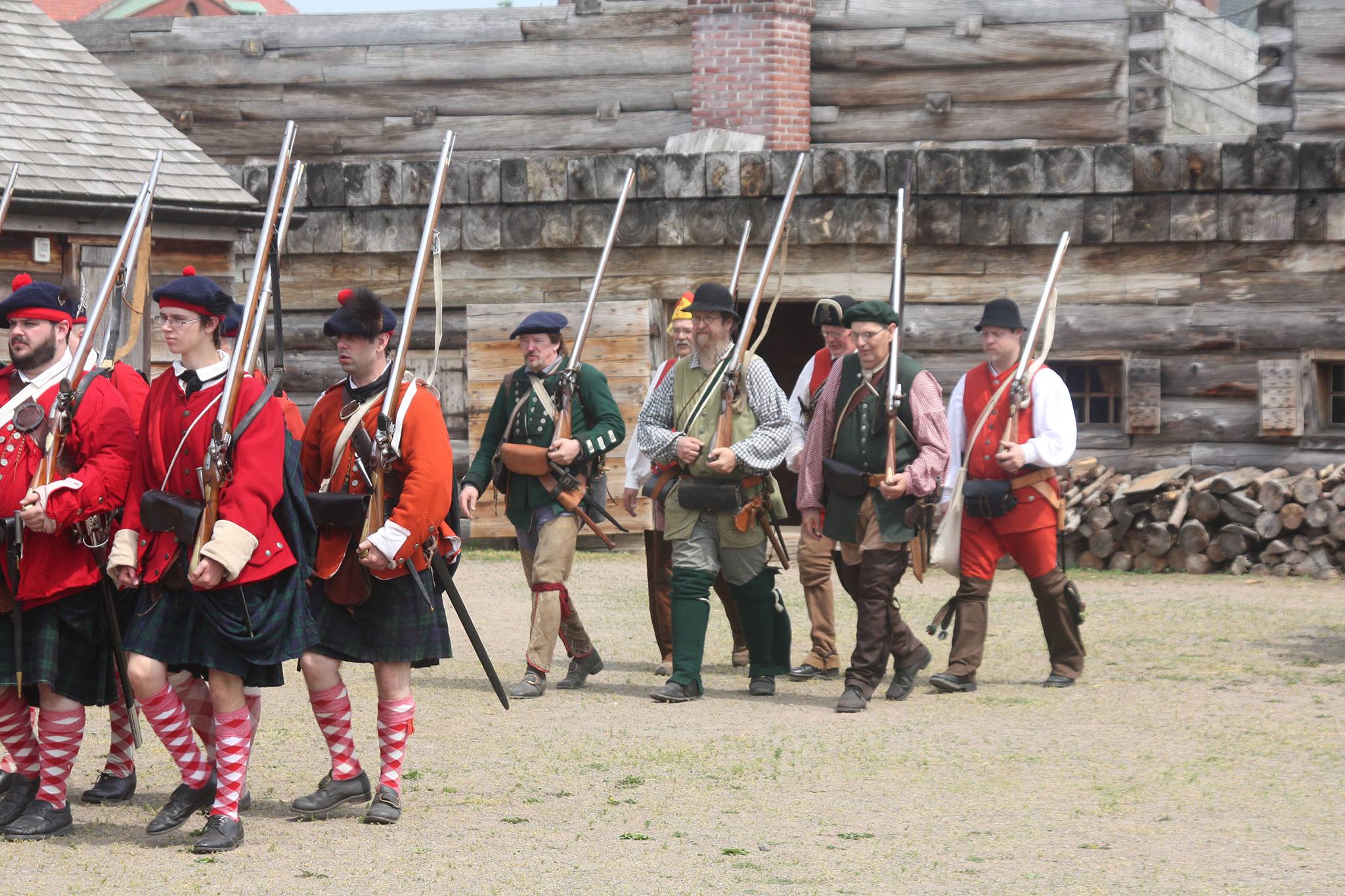 Rows of soldiers marching inside the fort. They are in lines carrying their muskets. 