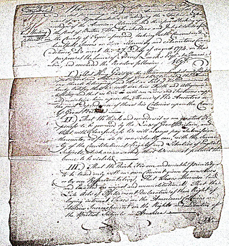 An old, yellowing tattered document with longhand cursive writing and inky blotches. 