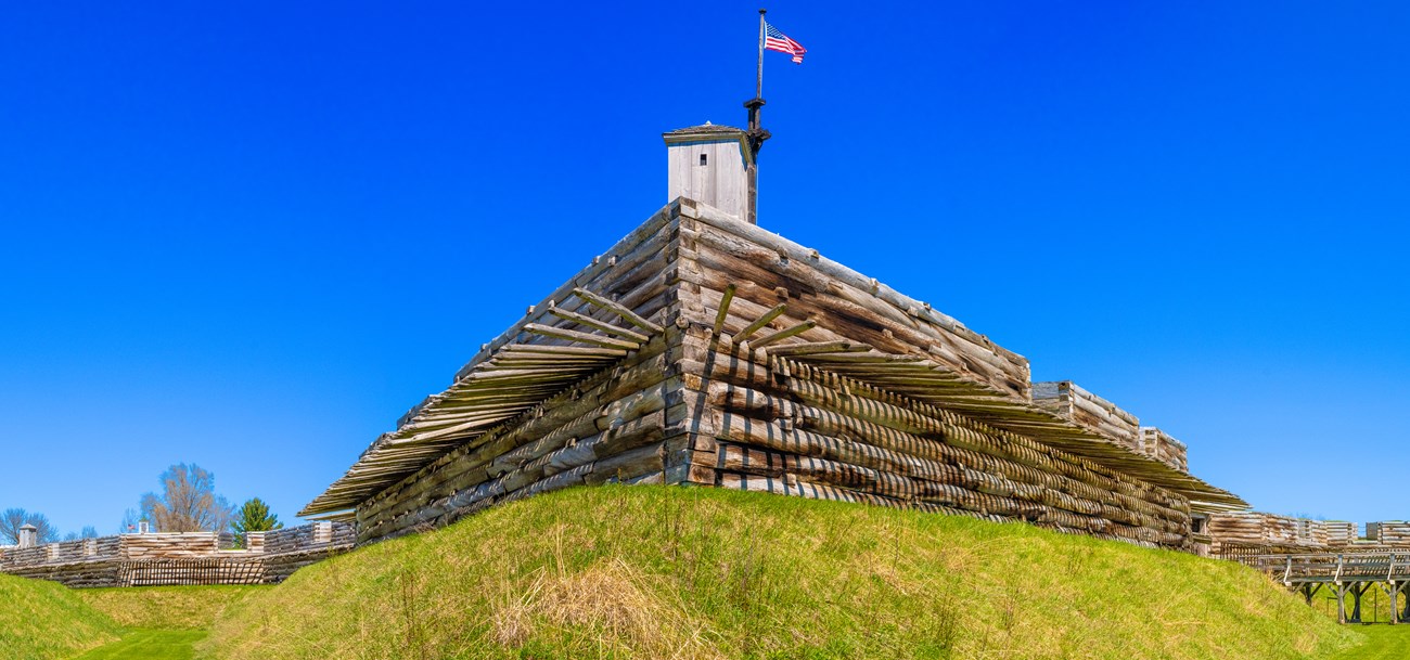 A large wooden picket fence on your right and the fort on your left.